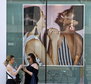 Woman standing by glass window in store