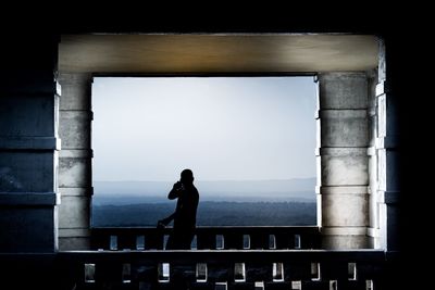 Woman standing by bridge against sky