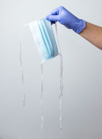Midsection of person holding ice over white background