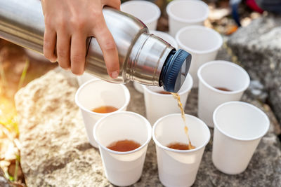 Cropped hand of woman holding coffee on table