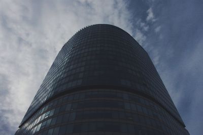 Low angle view of modern building against cloudy sky