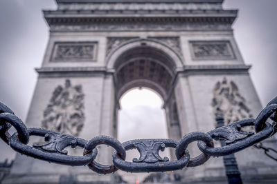 Close-up of chain against arc de triomphe