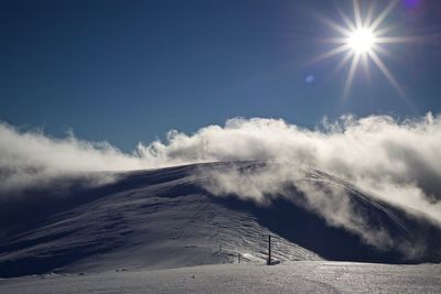 Scenic view of snowcapped mountains against sky on sunny day