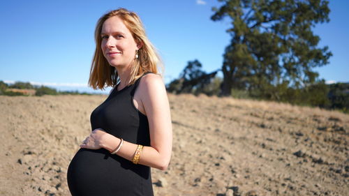 Portrait of smiling woman standing on land