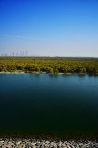 Scenic view of lake against clear blue sky