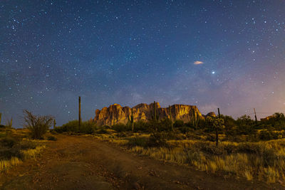 Scenic view of landscape against star field at night