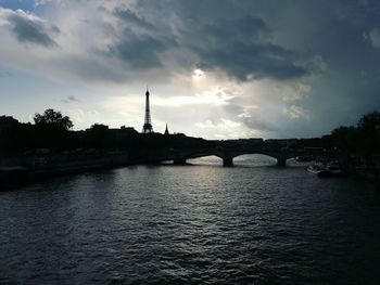 Bridge over river in city against sky