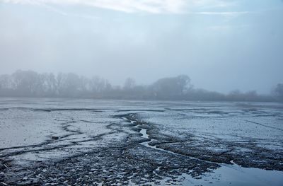 Scenic view of frozen lake against sky during winter
