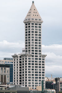 Low angle view of buildings against cloudy sky