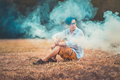 Young woman sitting on grass at night