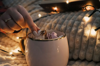 Christmas decorations with lights, hot drink, fruits and a good book