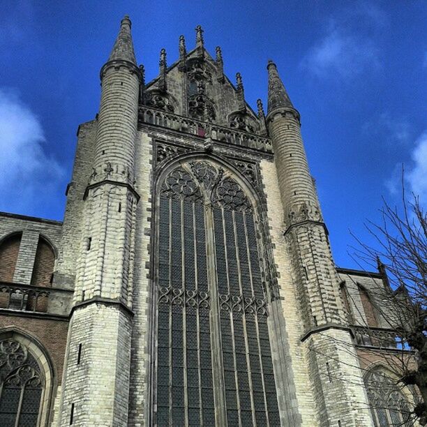 architecture, built structure, building exterior, low angle view, church, place of worship, religion, sky, spirituality, blue, cathedral, history, arch, famous place, tower, travel destinations, old, outdoors