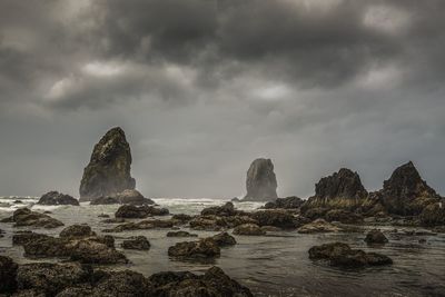 Rocks on sea shore against sky