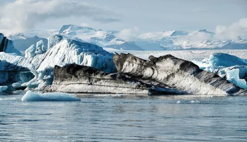 Scenic view of snowcapped landscape by sea against sky - iceland jökulsarlon glacierlagoon icebergs 