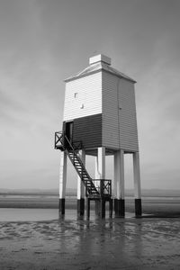 Lifeguard hut on beach against sky