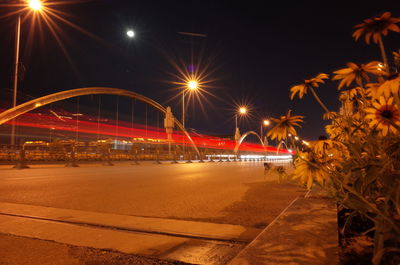 Illuminated light trails on road against sky at night