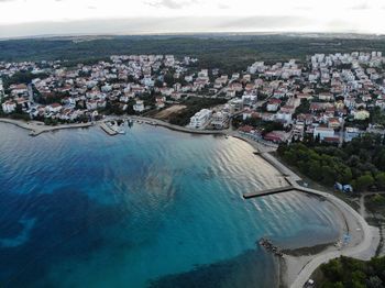 High angle view of buildings and sea against sky