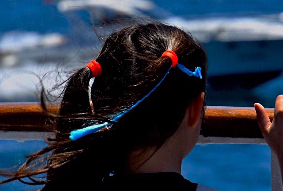 REAR VIEW OF WOMAN HOLDING BOAT