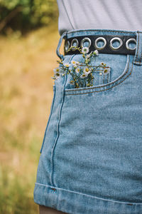 Midsection of woman wearing shorts with flowers in pocket