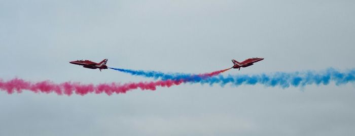 Low angle view of airshow against sky