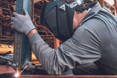 Midsection of man working on metal