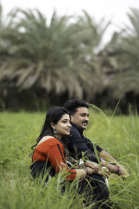 Portrait of smiling couple sitting on field