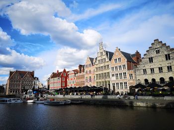 Panoramic view of buildings by river against sky in city