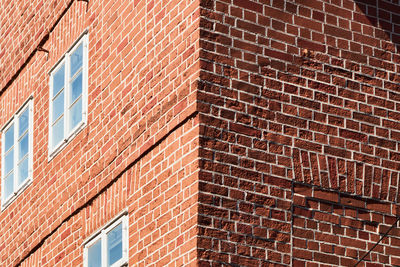 Corner of a house made of red bricks with one wall in sunshine and the other in shadow, abstract