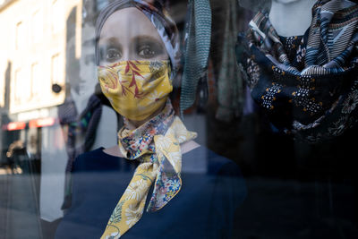 Midsection of woman standing by window at store