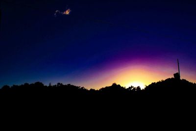 Silhouette trees against sky at night