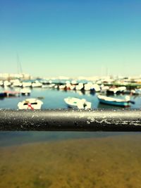 Close-up of boats moored at harbor against clear sky