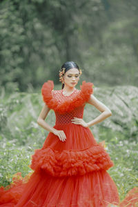 Portrait of young woman standing on field