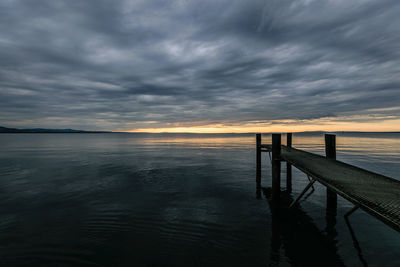 Pier over sea against sky during sunset