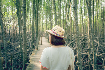 Rear view of woman wearing hat in forest