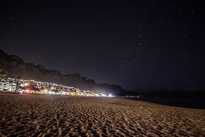 Scenic view of beach against clear sky at night