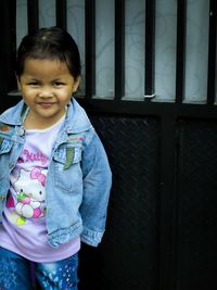 Cute smile little girl in blue jacket in park