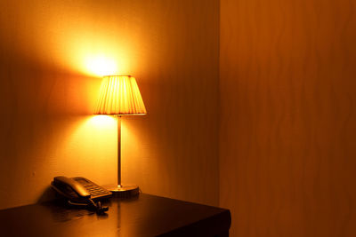 Illuminated electric lamp on bed at home