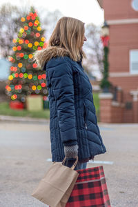 Side view of woman standing in snow