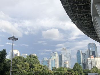 Modern buildings in city against cloudy sky