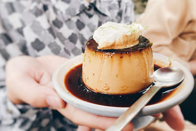 Close-up of hand holding pudding