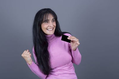 Beautiful woman with gesture of celebration with credit card