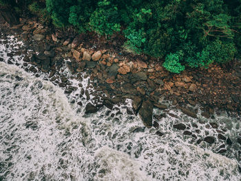 High angle view of stream flowing through rocks in forest