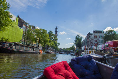 Man by river in city against sky