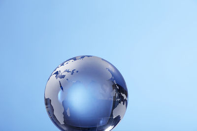 Close-up of globe against blue background