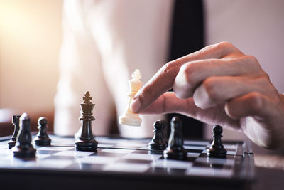 Midsection of businessman playing chess in office