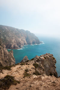 Scenic view of sea and mountains against sky