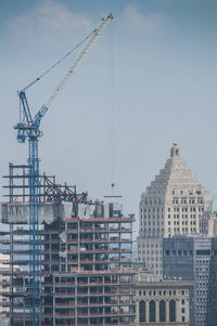Low angle view of crane against sky