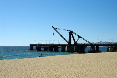 Lifeguard hut on beach against clear blue sky