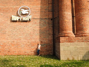 Full length of girl standing against building