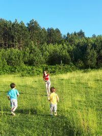 Rear view of people with children on land